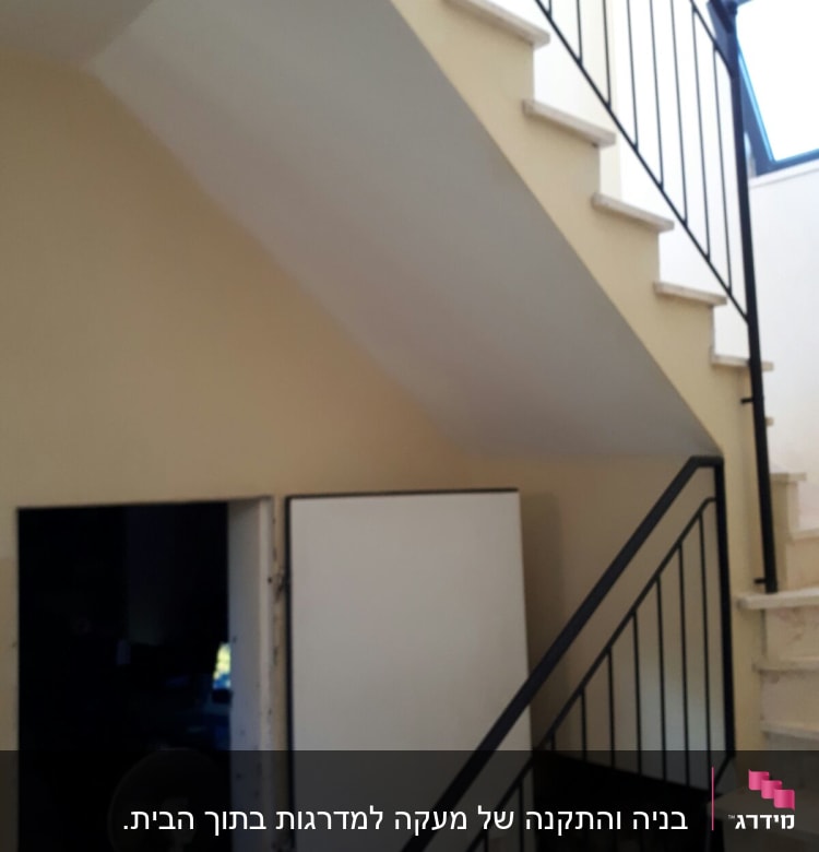 מעקה מתכת שחור ליד מדרגות לבנות